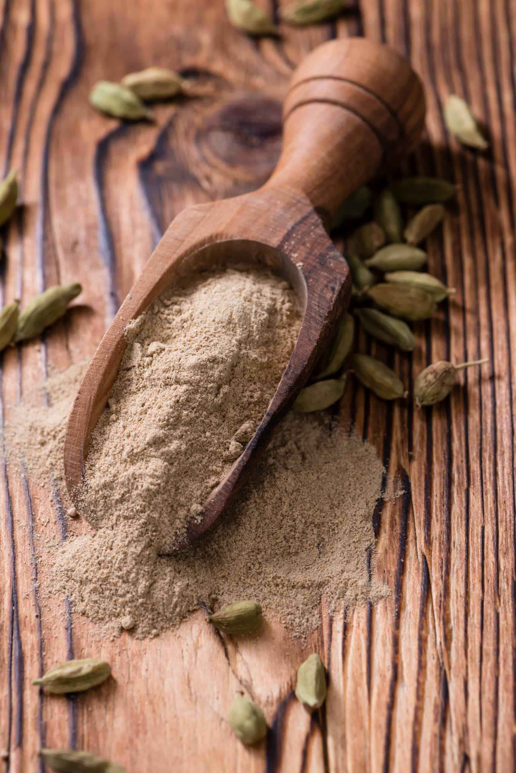 Heap of Cardamon Powder (close-up shot) on rustic wooden background - best substitute for cardamom 