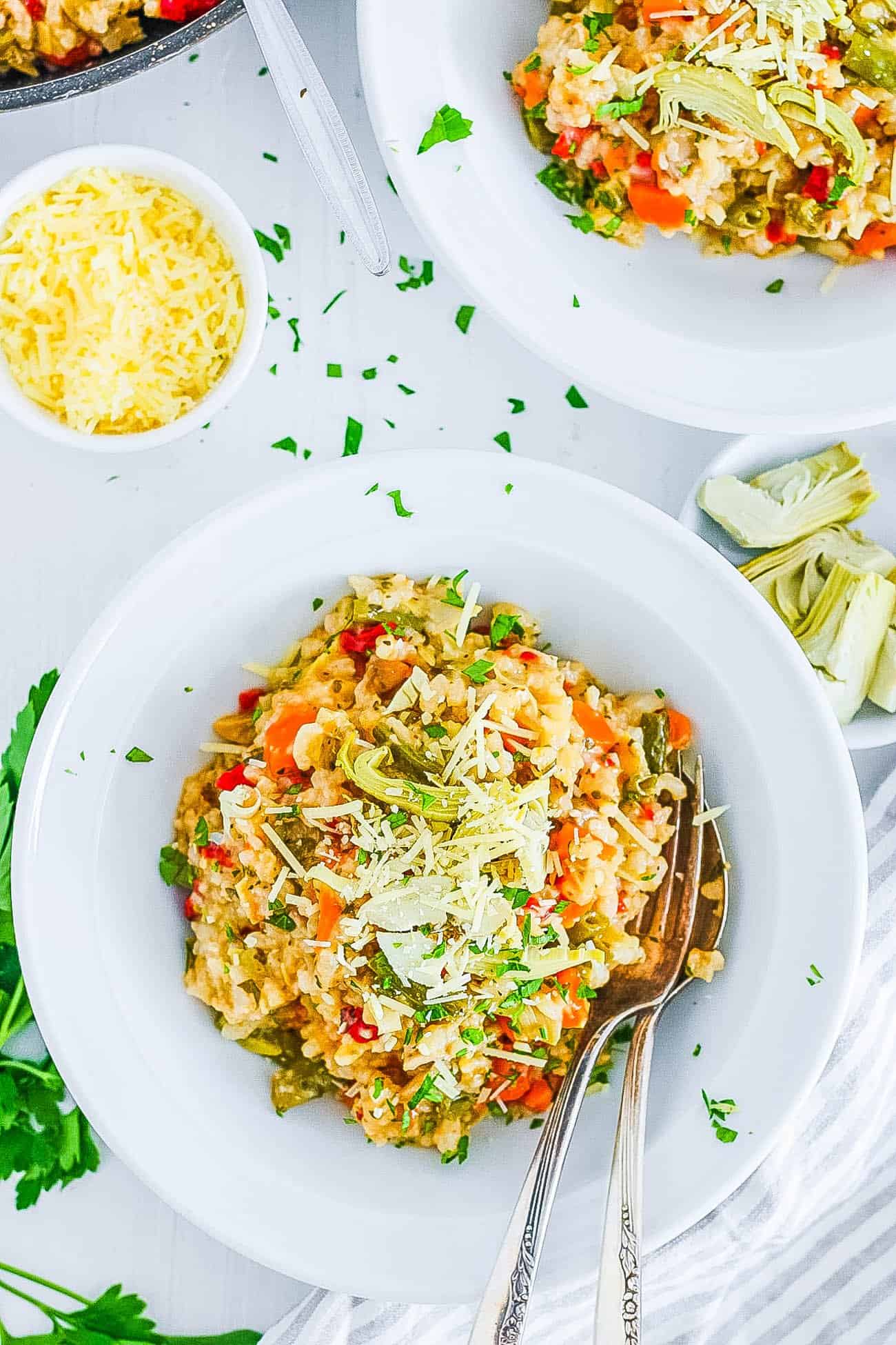 healthy risotto with garlic, parmesan, truffle, mushrooms, artichokes, and green beans on a white plate (gluten free, vegetarian, instant pot recipe)