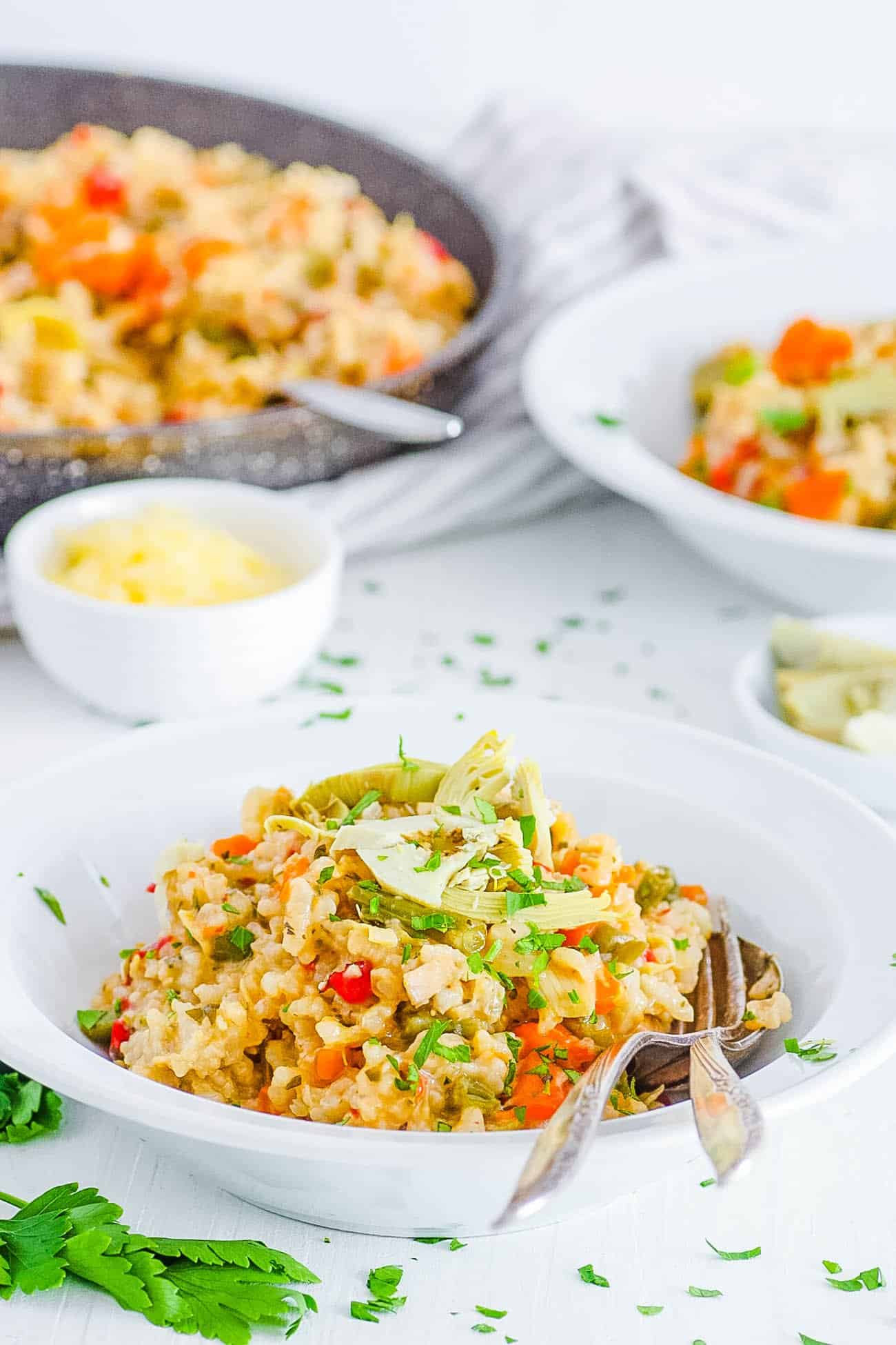 healthy risotto with garlic, parmesan, truffle, mushrooms, artichokes, and green beans on a white plate (gluten free, vegetarian, instant pot recipe)