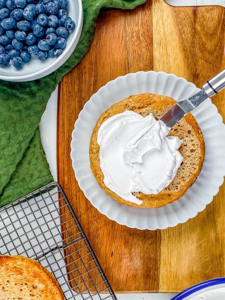 Spreading the coconut cream on the bottom layer of the smash cake.