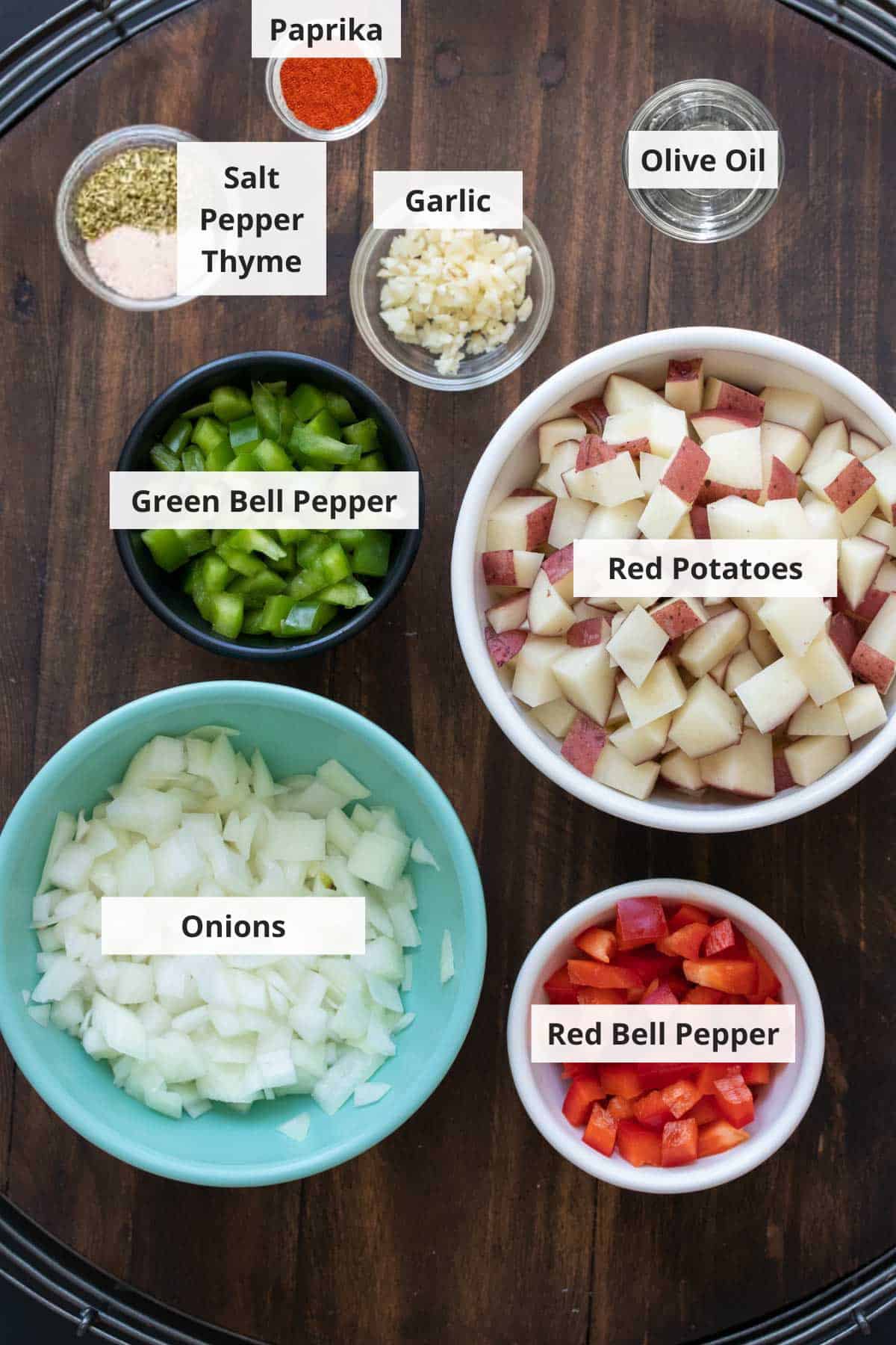 Ingredients for roasted breakfast potatoes on a wood background.