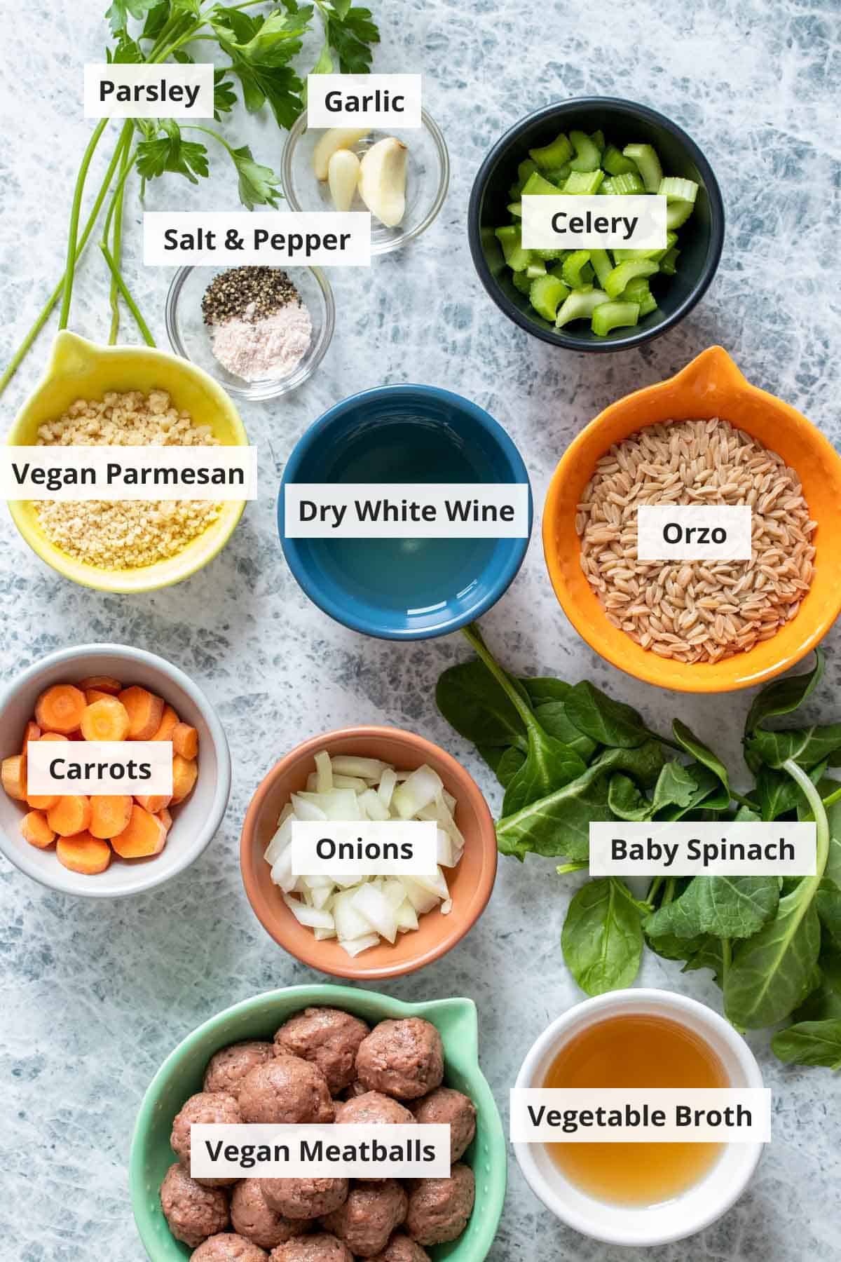 Ingredients for vegan Italian wedding soup on a marble countertop.