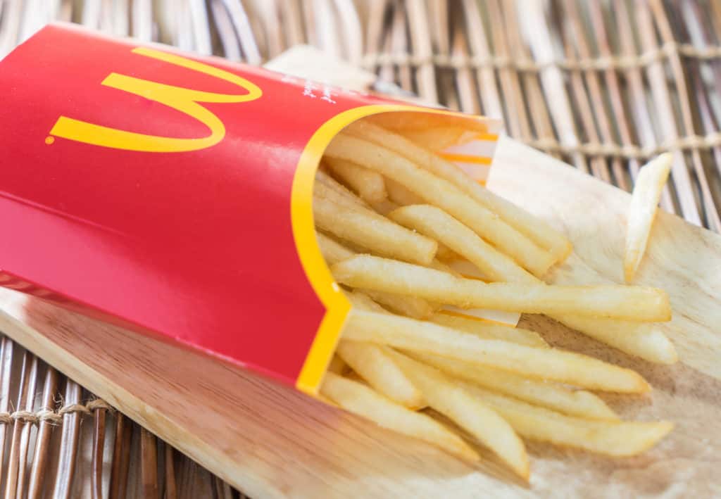 Are McDonald's Fries Vegetarian - A box of Mc Donalds French Fries on a wooden tray.