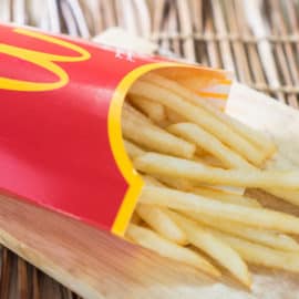 Are McDonald's Fries Vegetarian - A box of Mc Donalds French Fries on a wooden tray.
