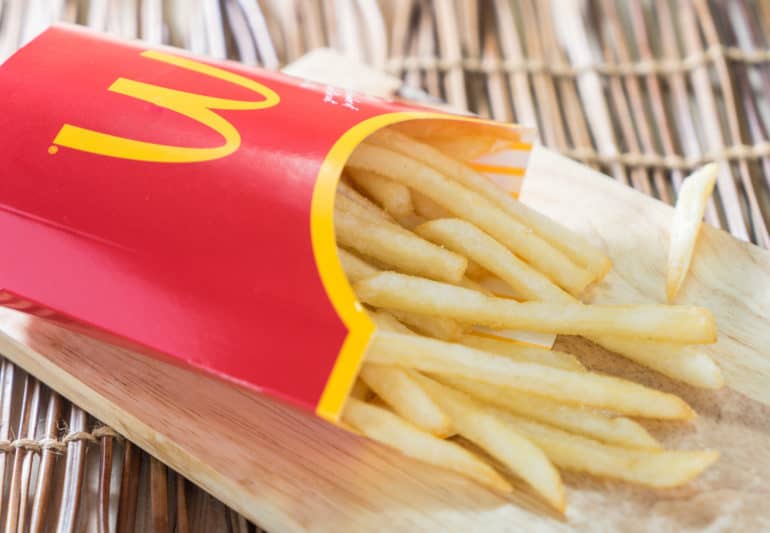 Are McDonald's Fries Vegetarian - A box of Mc Donalds French Fries on a wooden tray.