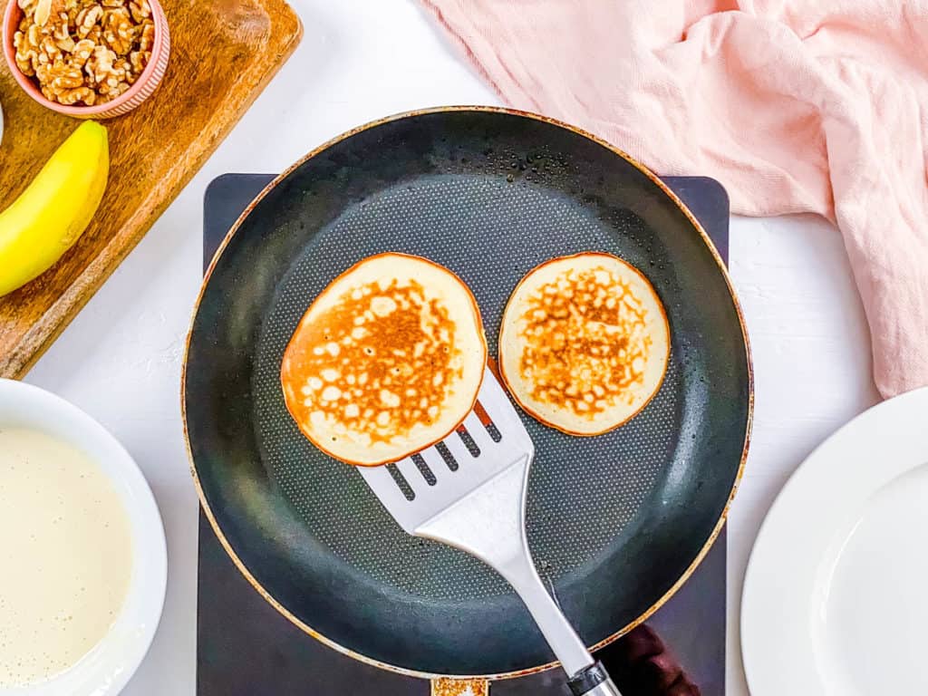 Flipping pancakes on a skillet.