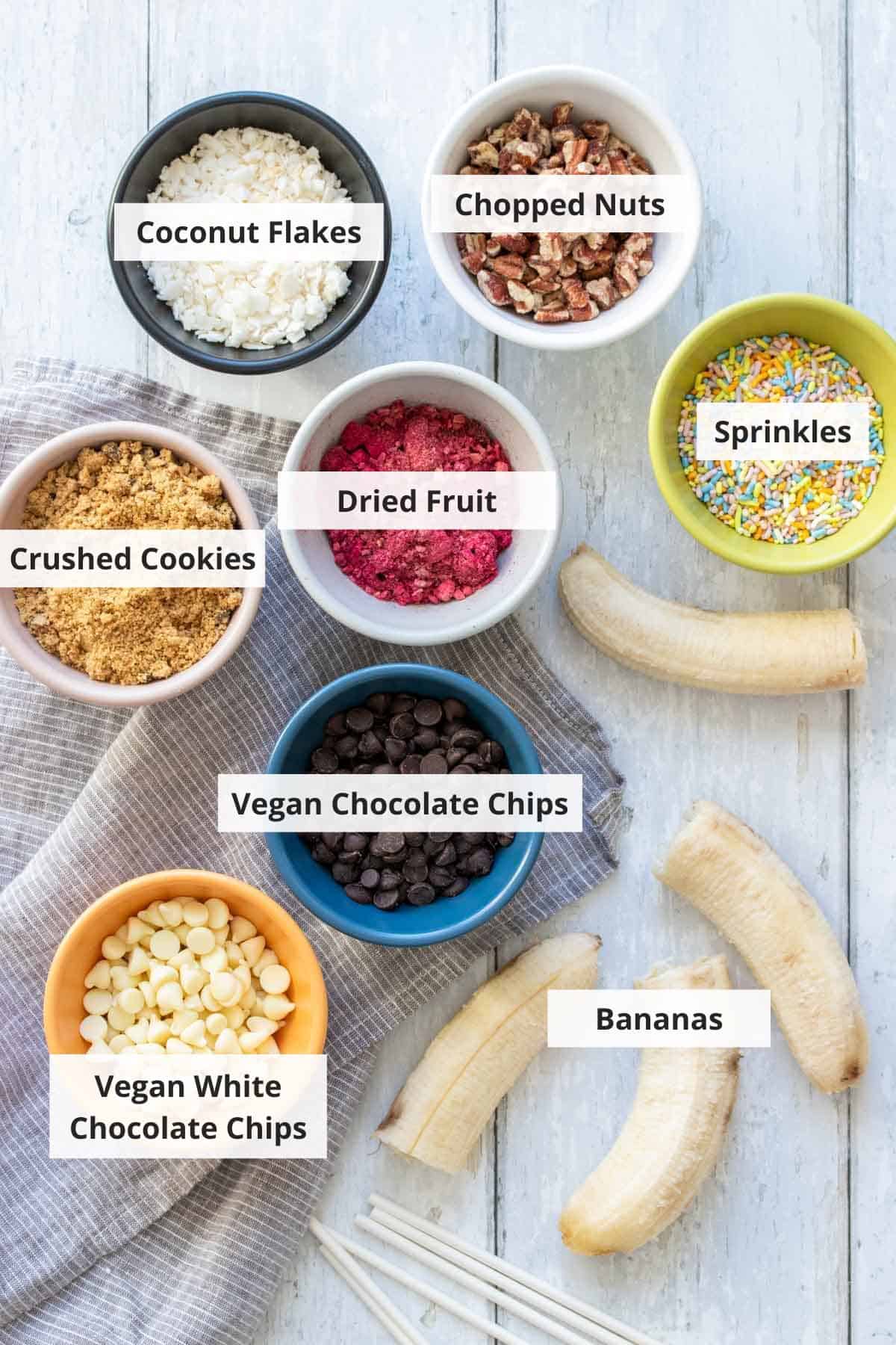 Ingredients for frozen chocolate covered bananas recipe on a blue wood countertop.