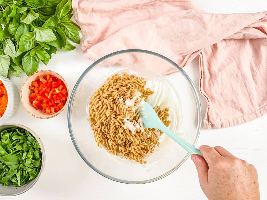 pasta mixed with dressing in a bowl