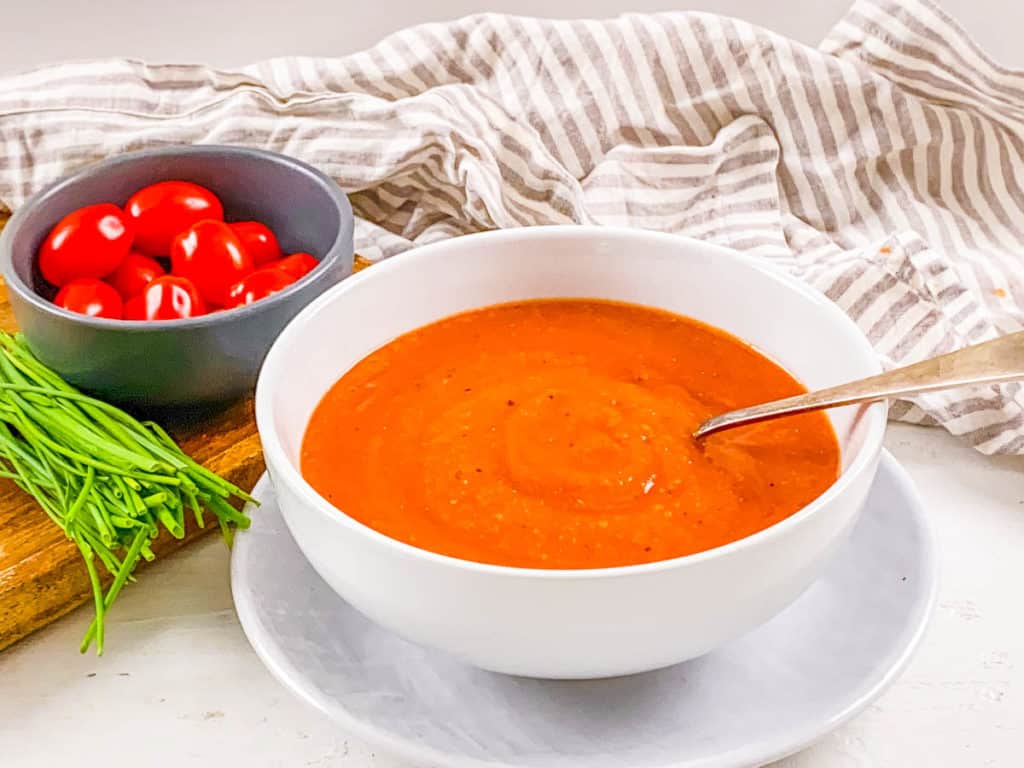 vegan roasted tomato basil soup served in a white bowl