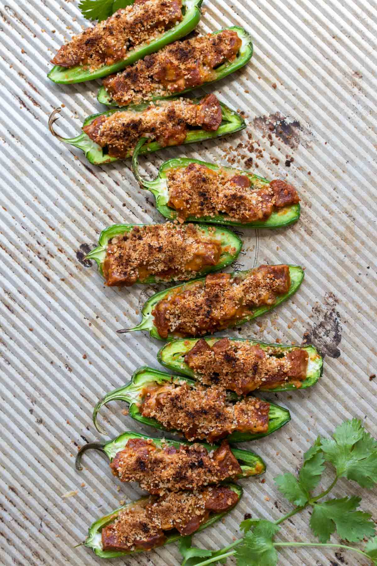 Top view of vegan jalapeño poppers on a baking sheet.