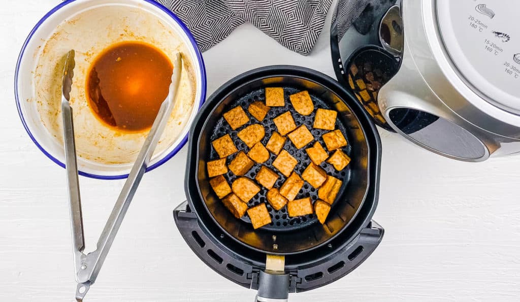 Adding the tempeh to the air fryer.