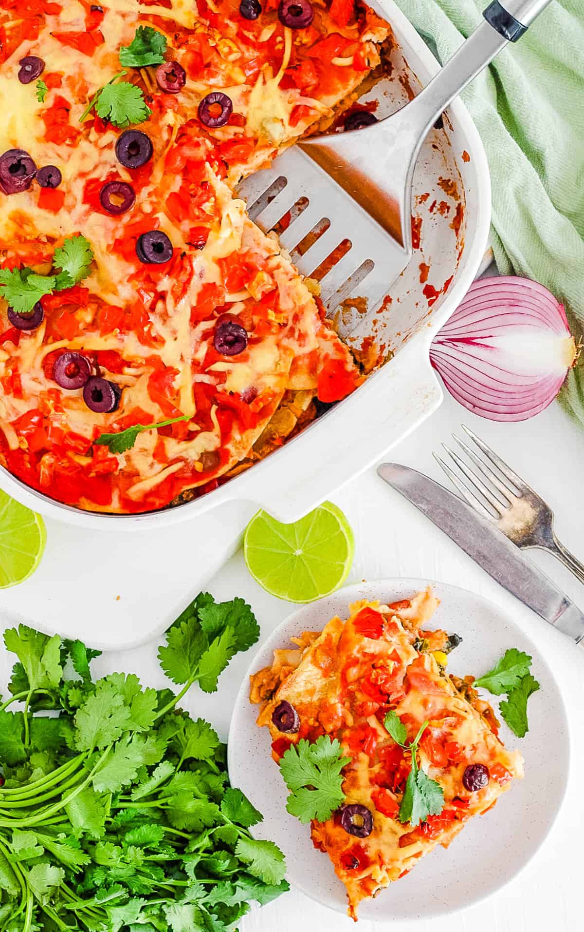 easy healthy vegetarian layered taco casserole with tortillas in a white baking dish