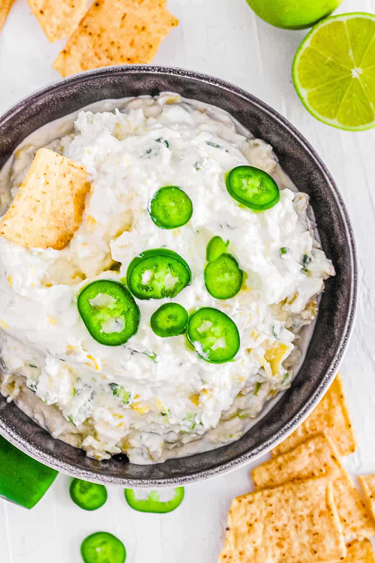 easy vegetarian cold jalapeno artichoke dip recipe in a bowl with chips
