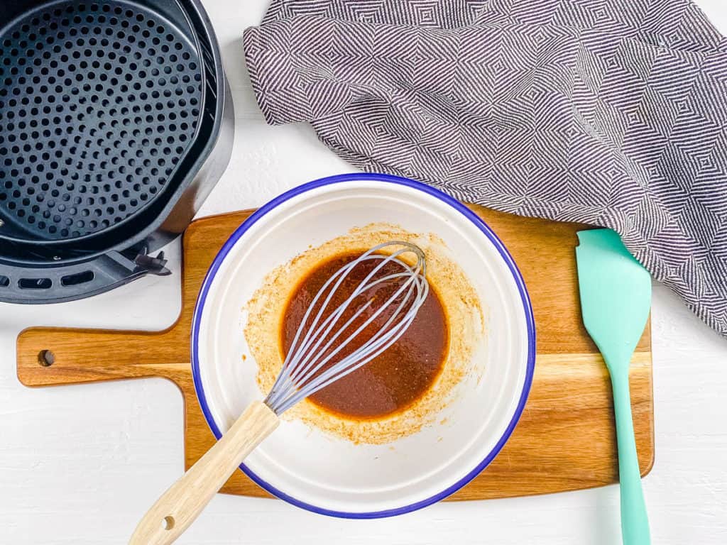 Whisking up a marinade in a blue-rimmed mixing bowl.