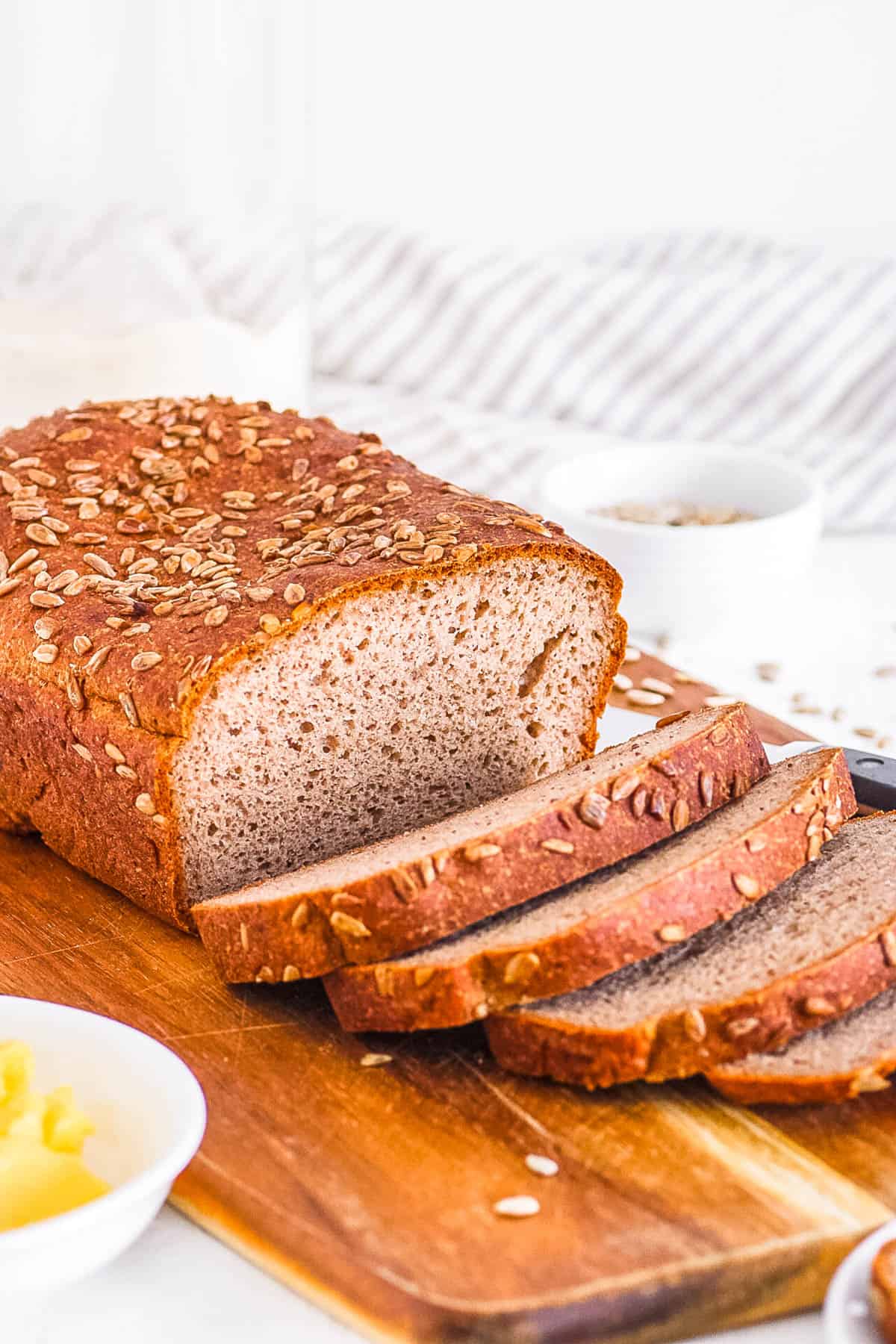 دستور تهیه نان گندم سیاه سالم وگان بدون گلوتن آسان برش داده شده روی تخته برش