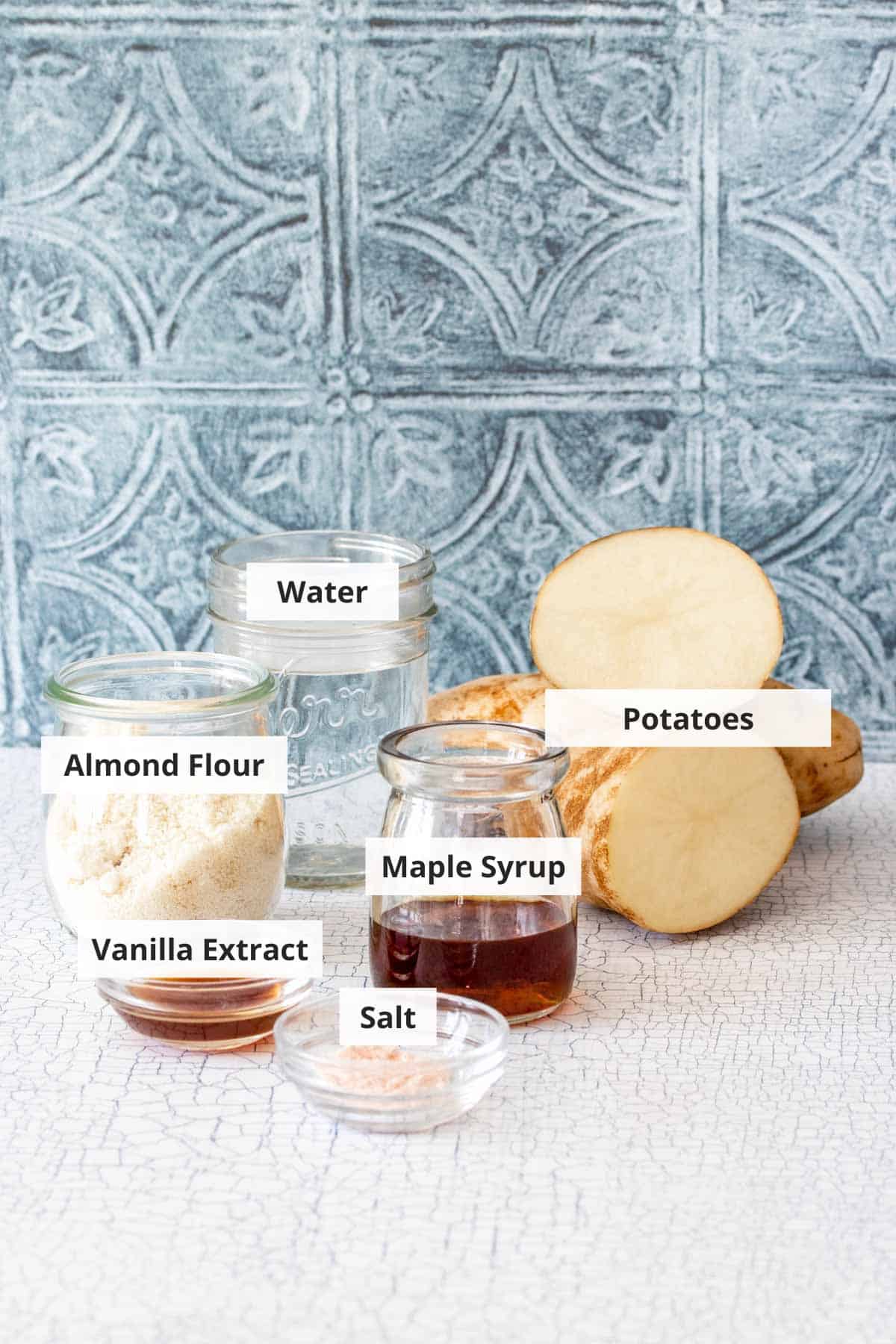 Ingredients for potato milk on a white countertop.