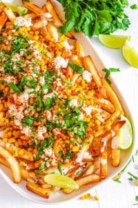 easy vegan gluten free healthy loaded corn fries recipe - mexican street corn fries on a white plate.