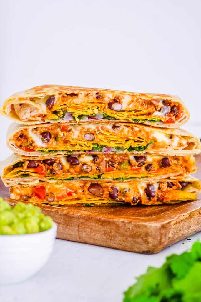 healthy vegan crunchwrap supreme - taco bell copycat recipe, stacked on a cutting board