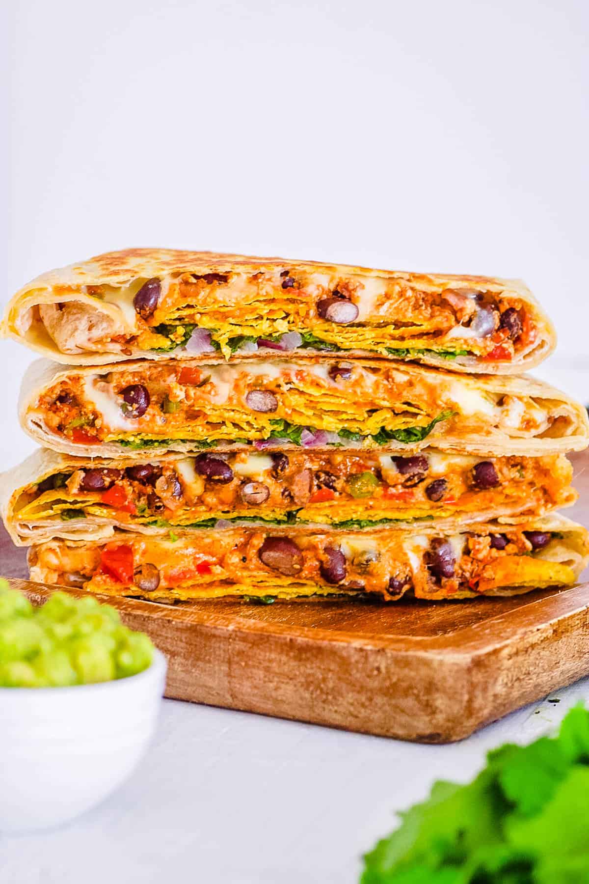 healthy vegan crunchwrap supreme - taco bell copycat recipe, stacked on a cutting board