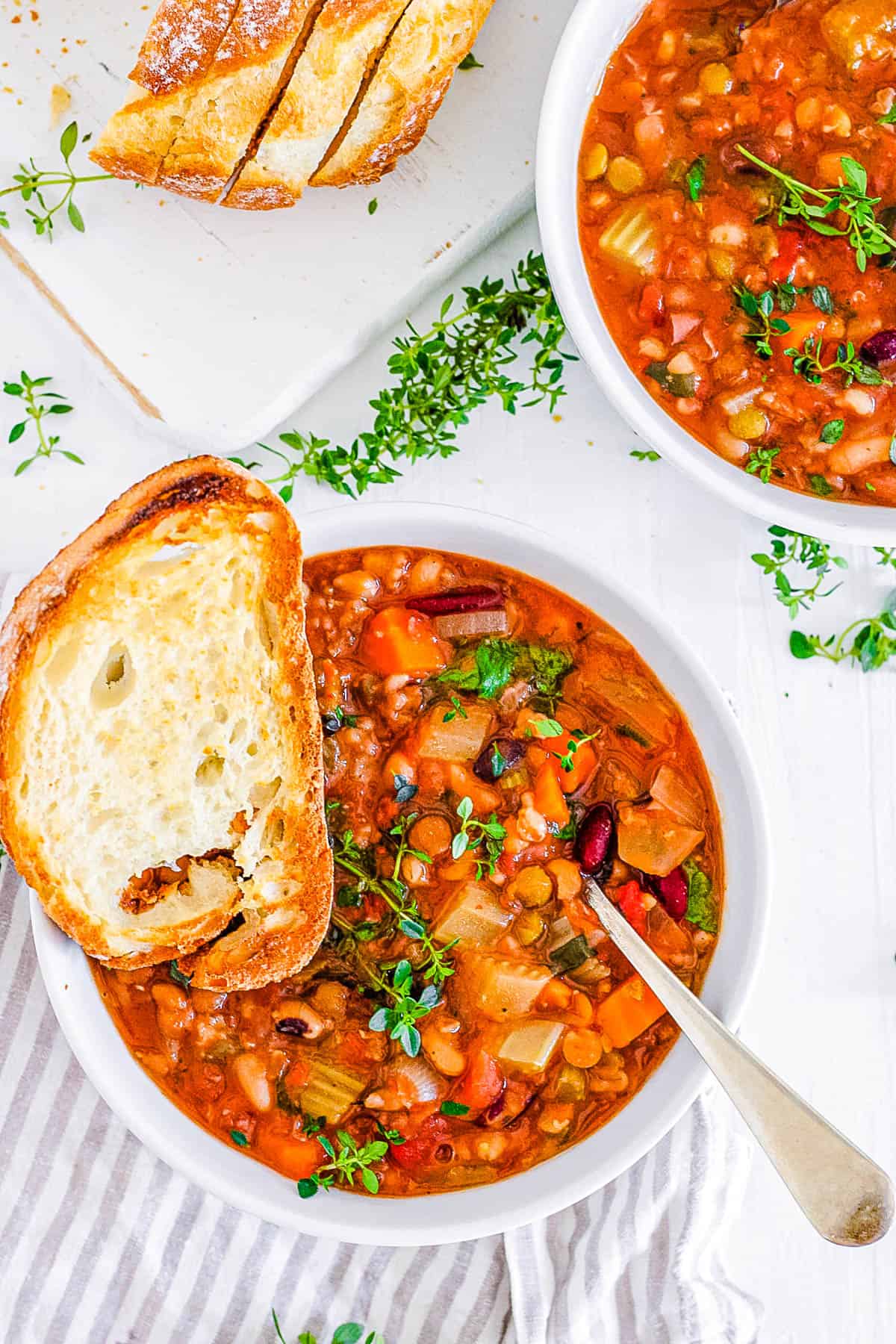 15 bean soup crock pot recipe served in a white bowl with garlic bread