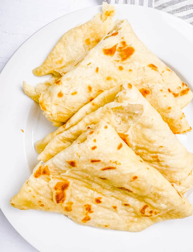 cooked guyanese roti on a white plate