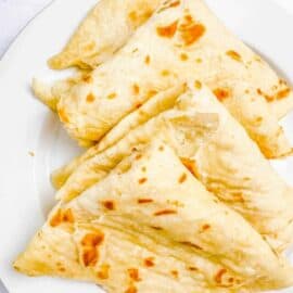cooked guyanese roti on a white plate