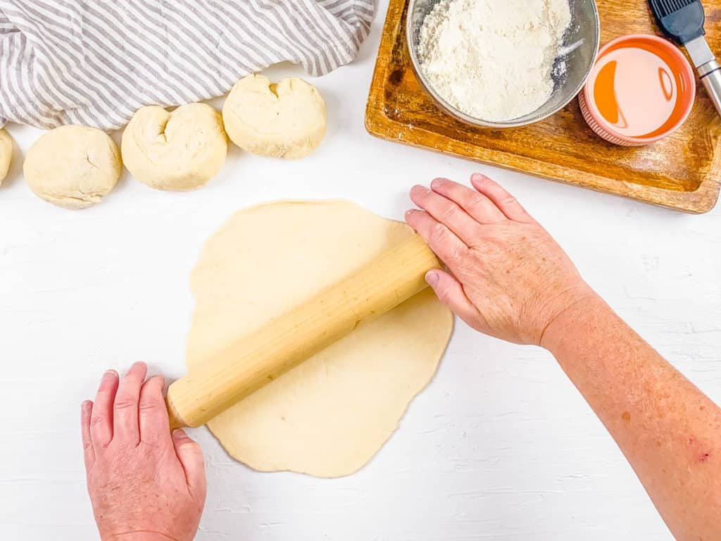 paratha roti dough rolled out on a cutting board