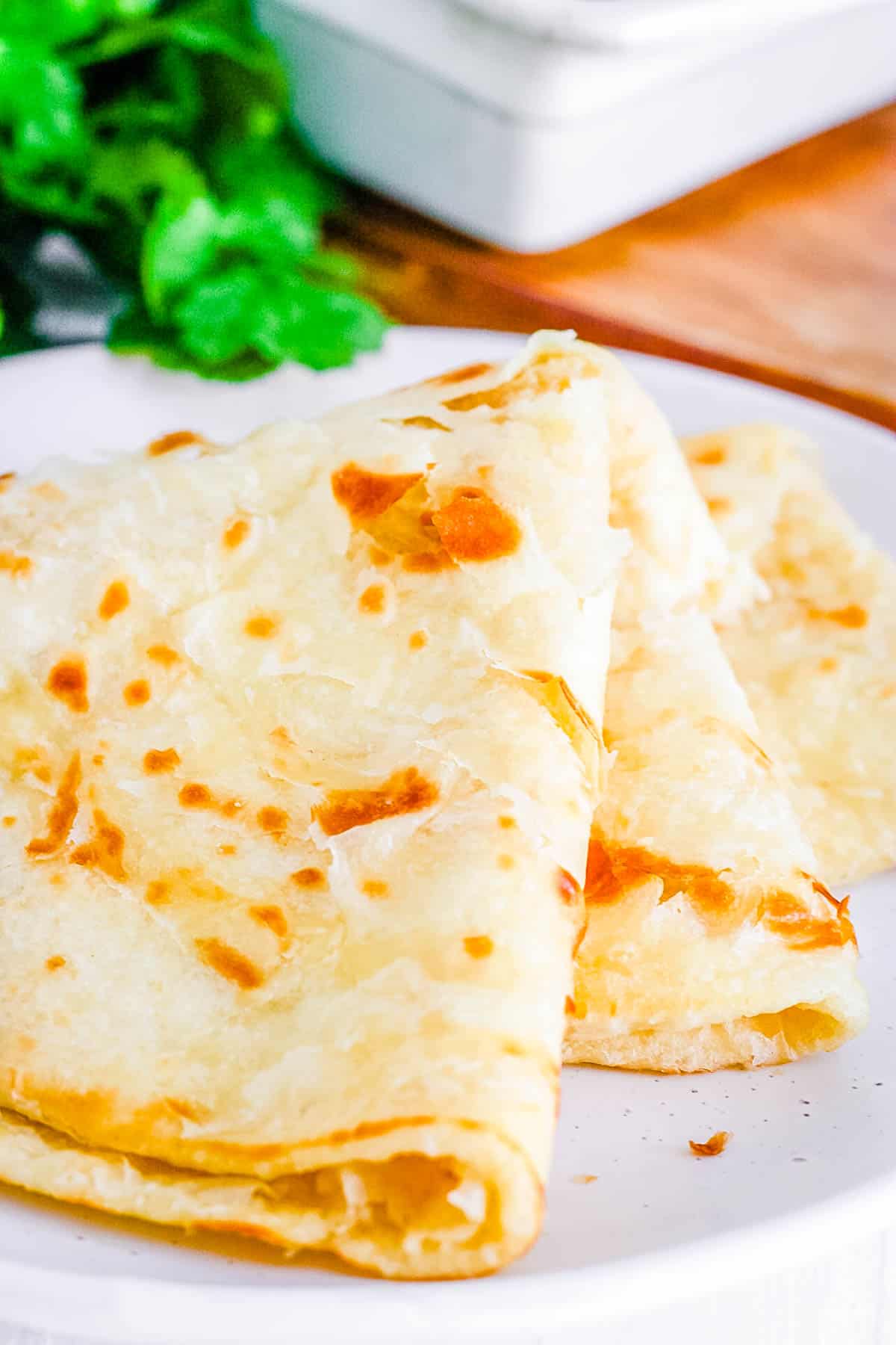 guyanese roti stacked on a white plate