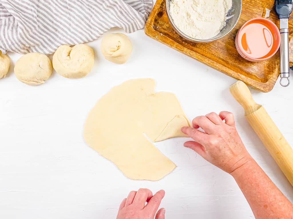 paratha dough on a cutting board rolled out