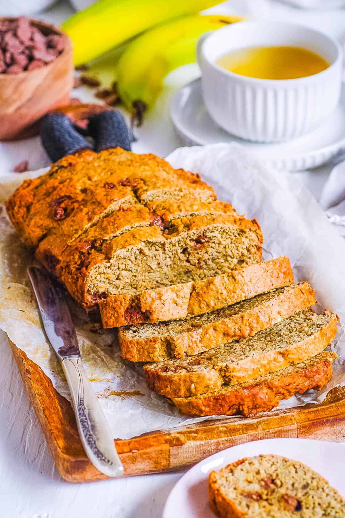 Healthy, gluten free chocolate chip banana bread sliced on parchment paper.