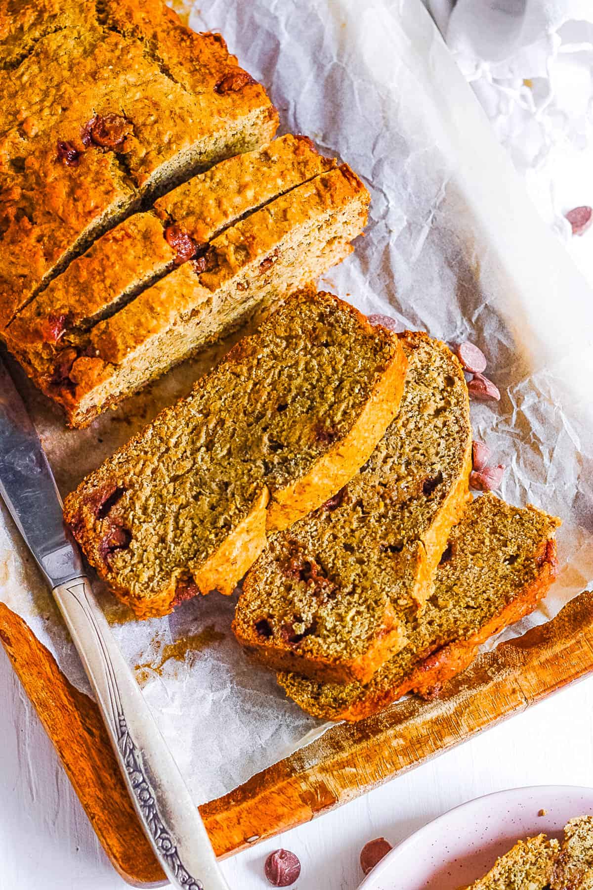 Healthy, gluten free chocolate chip banana bread sliced on parchment paper.