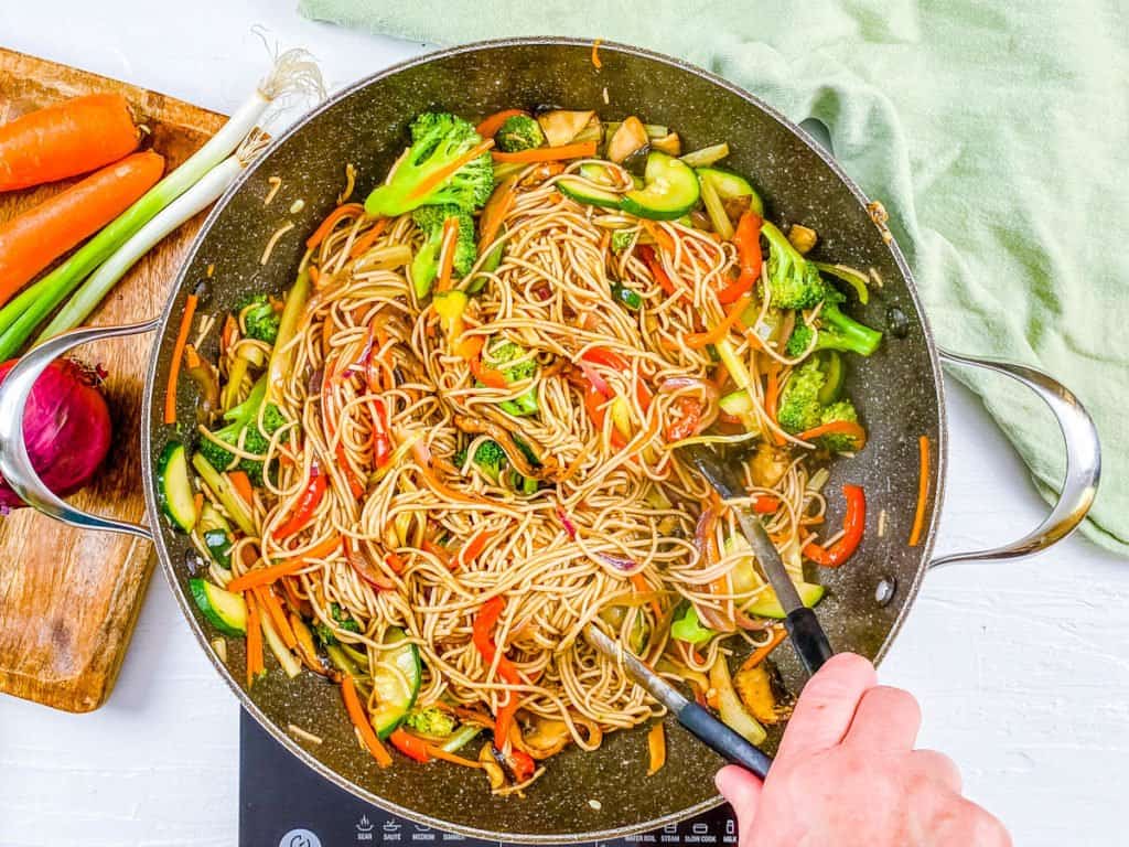 soba tossed with sauce and veggies in a pan