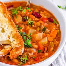 15 bean soup crock pot recipe served in a white bowl with garlic bread