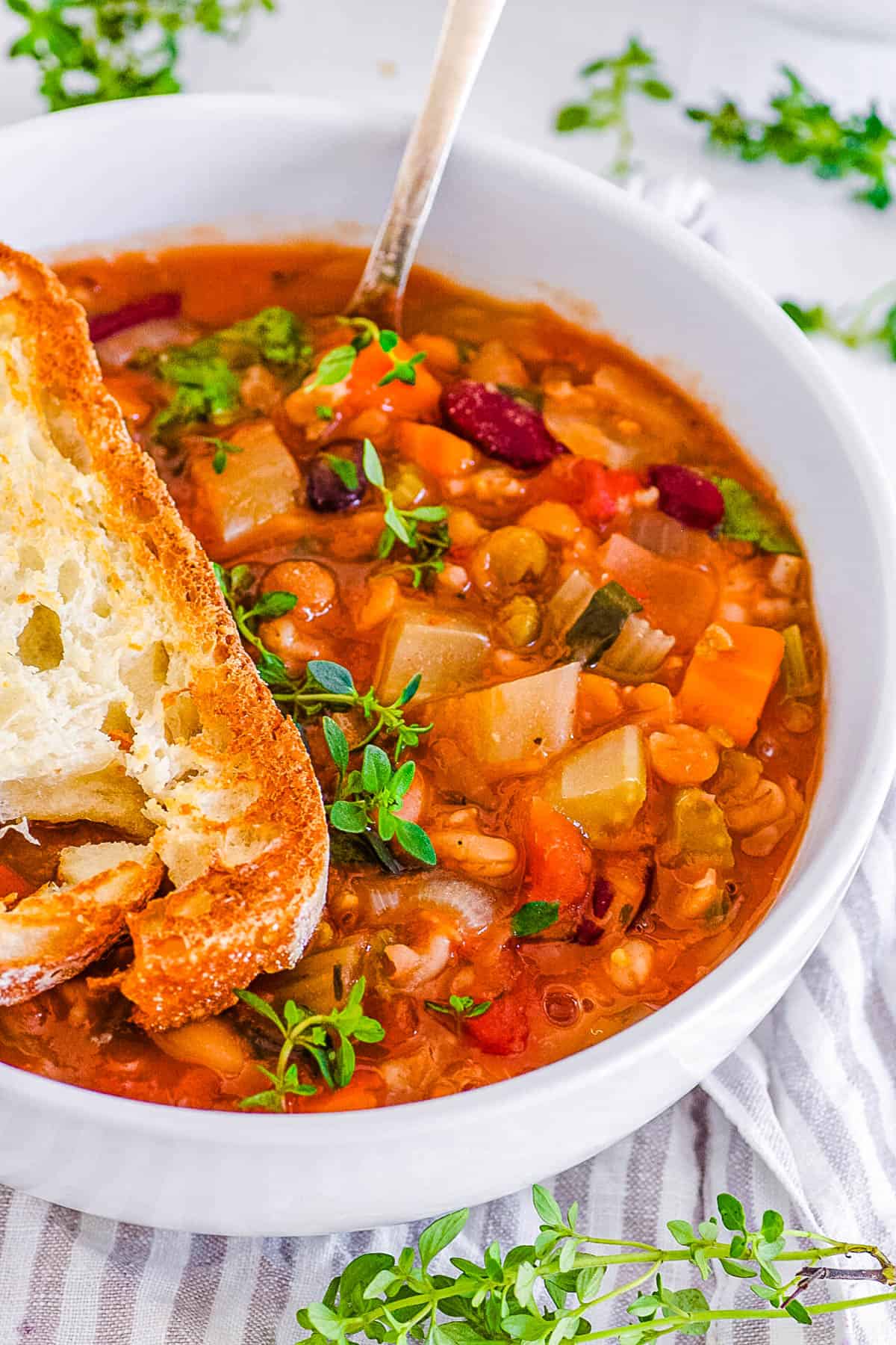 15 bean soup crock pot recipe served in a white bowl with garlic bread