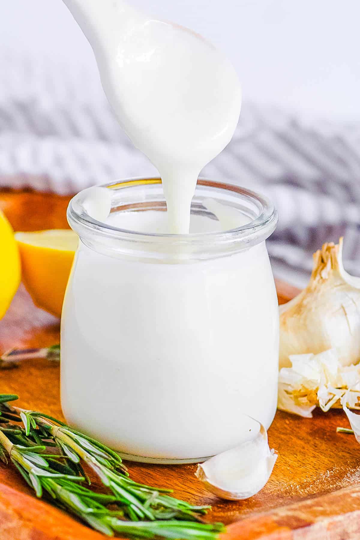 garlic vegan aioli recipe in a glass jar with a spoon