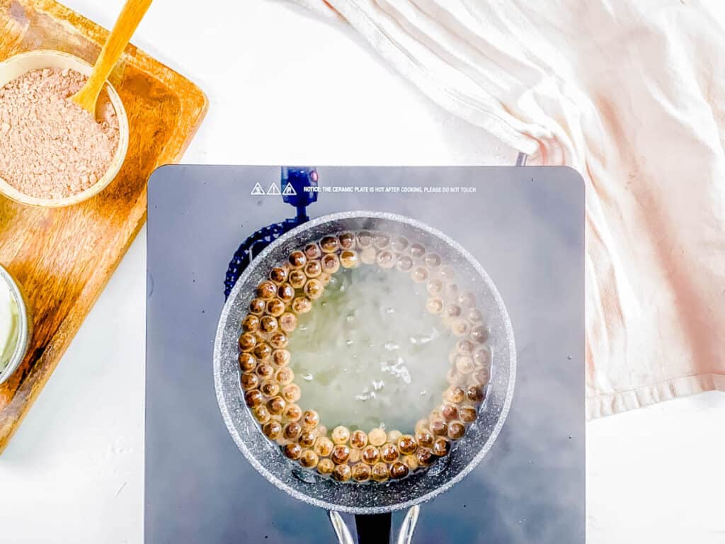 Tapioca pearls cooking in a pot.