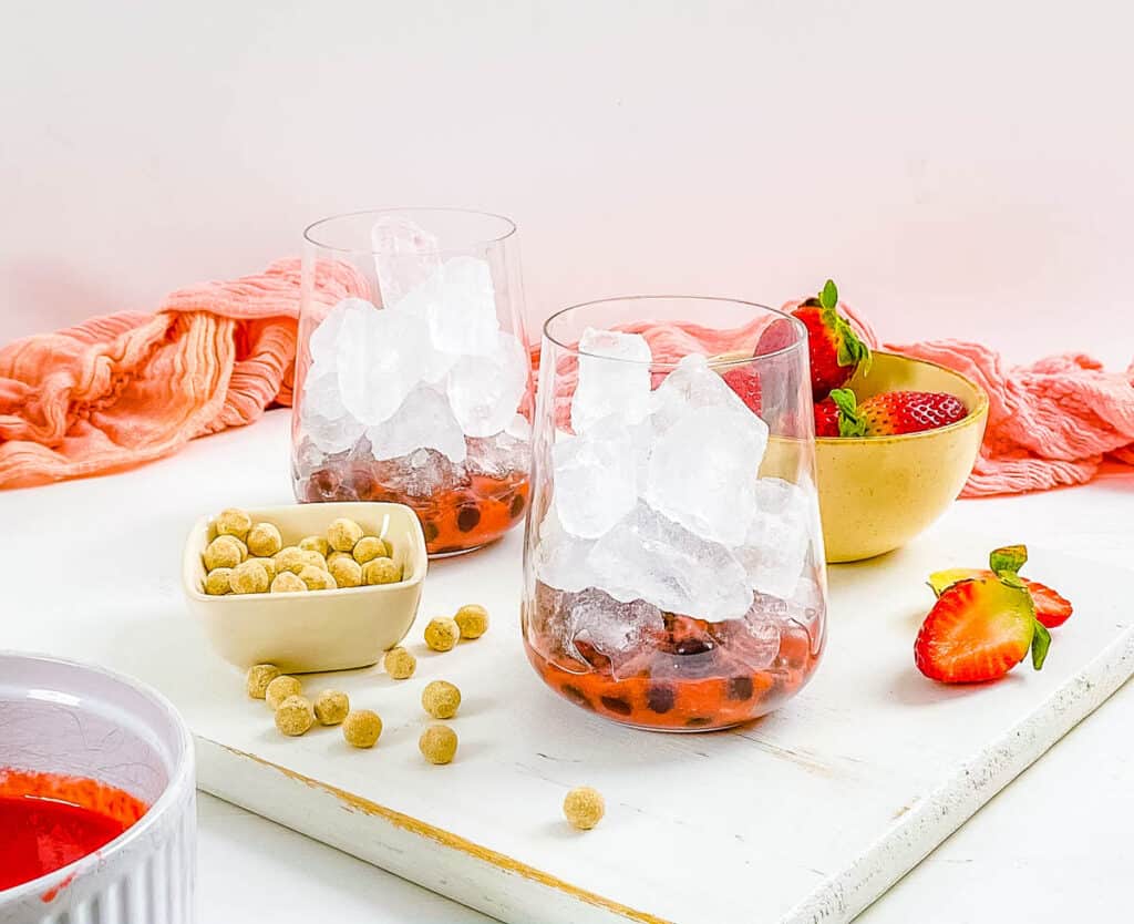 Πέρλες Boba, πάγος και πουρές φράουλας σε ένα ποτήρι.