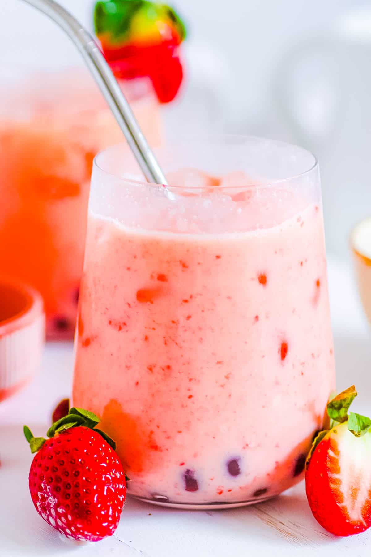 Strawberry milk tea with boba in a glass with a straw.