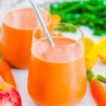 Easy apple carrot smoothie in a glass with a straw.