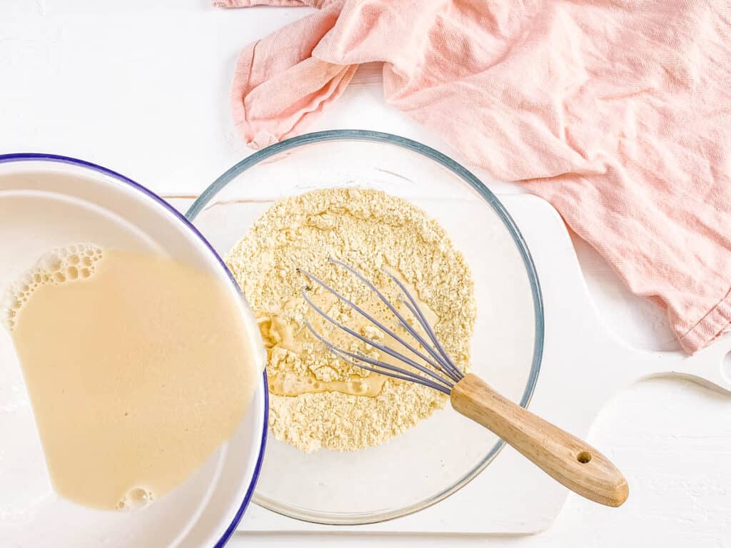 Dry ingredients about to be mixed with wet ingredients for keto coconut pancakes in a mixing bowl.