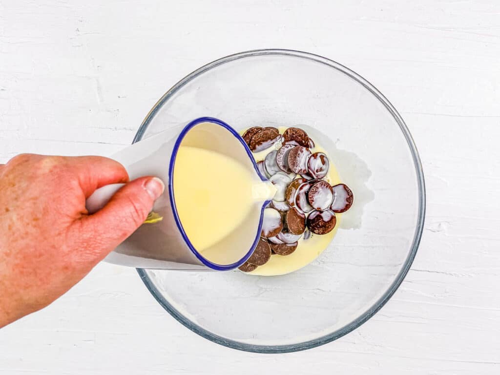 Cream and chocolate chips combined in a mixing bowl for Oreo tart filling.