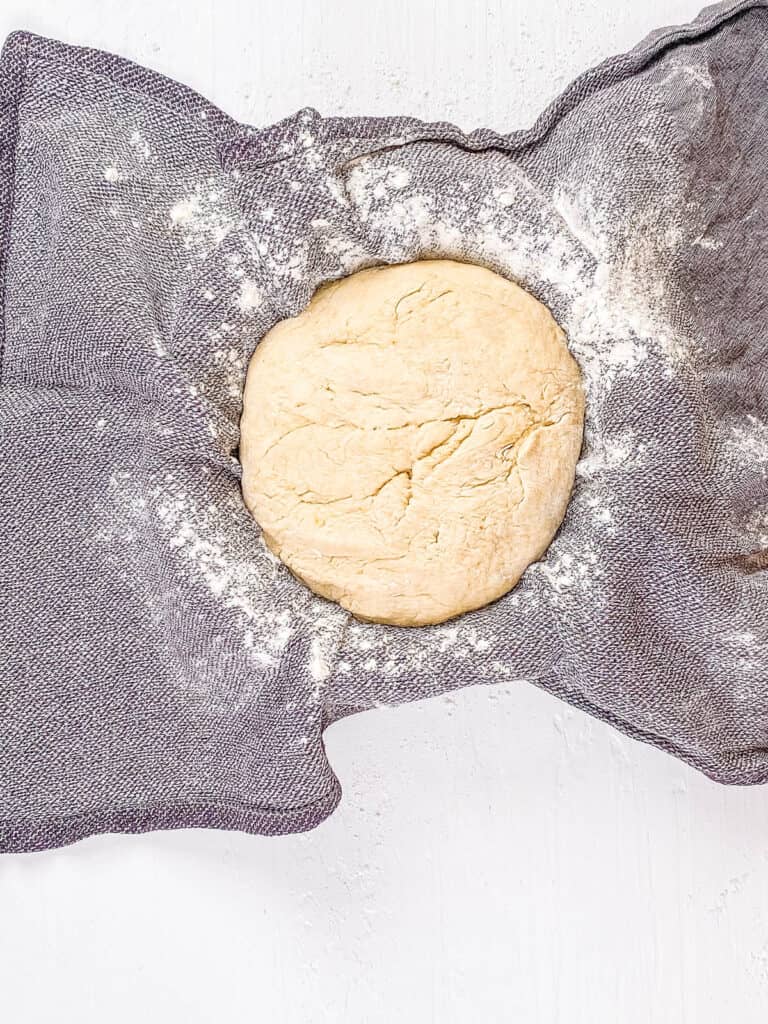 Uncooked bread dough resting in a cloth wrap.