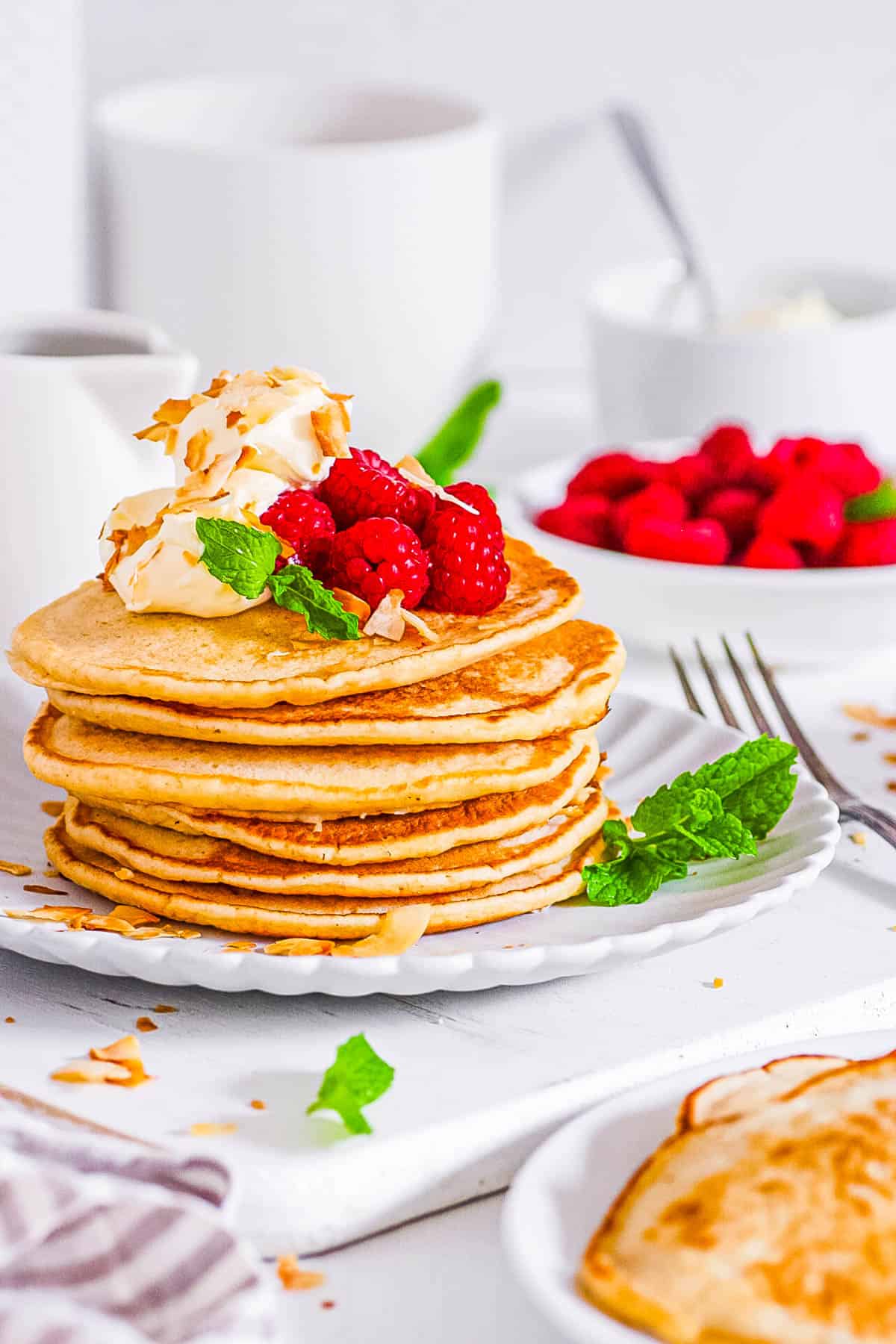 Fluffy sourdough discard pancakes stacked on a plate, topped with berries.