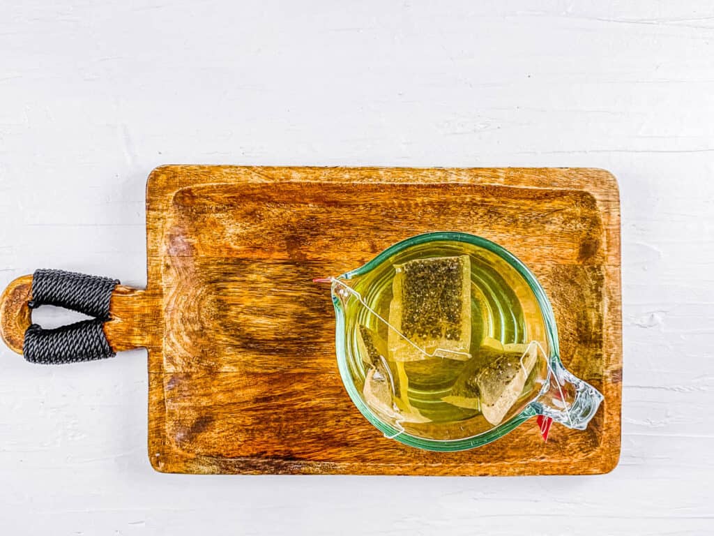 Green tea bags steeping in a glass.