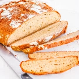 Sliced buckwheat sourdough bread on a white cutting board.