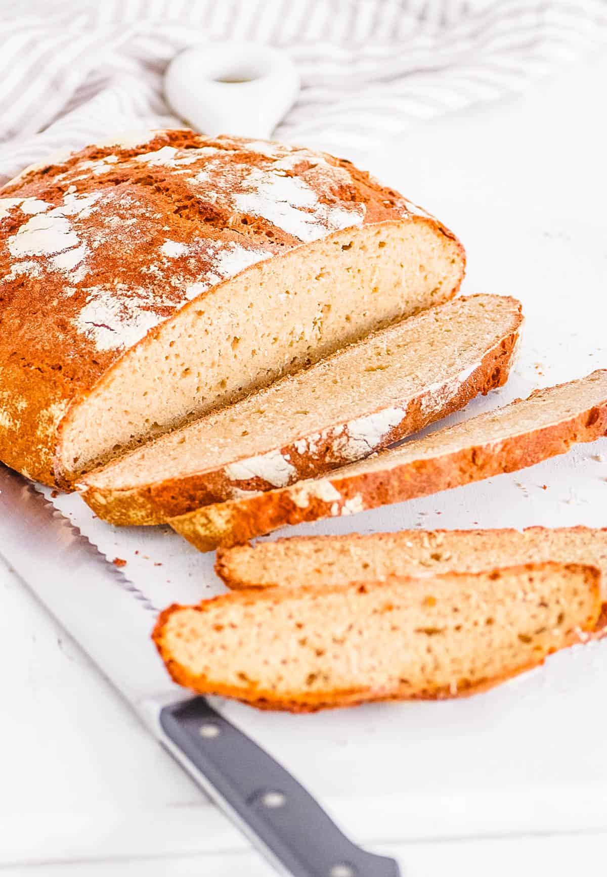 Sliced buckwheat sourdough bread on a white cutting board.