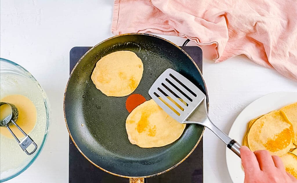 Pancake batter cooking in a pan.