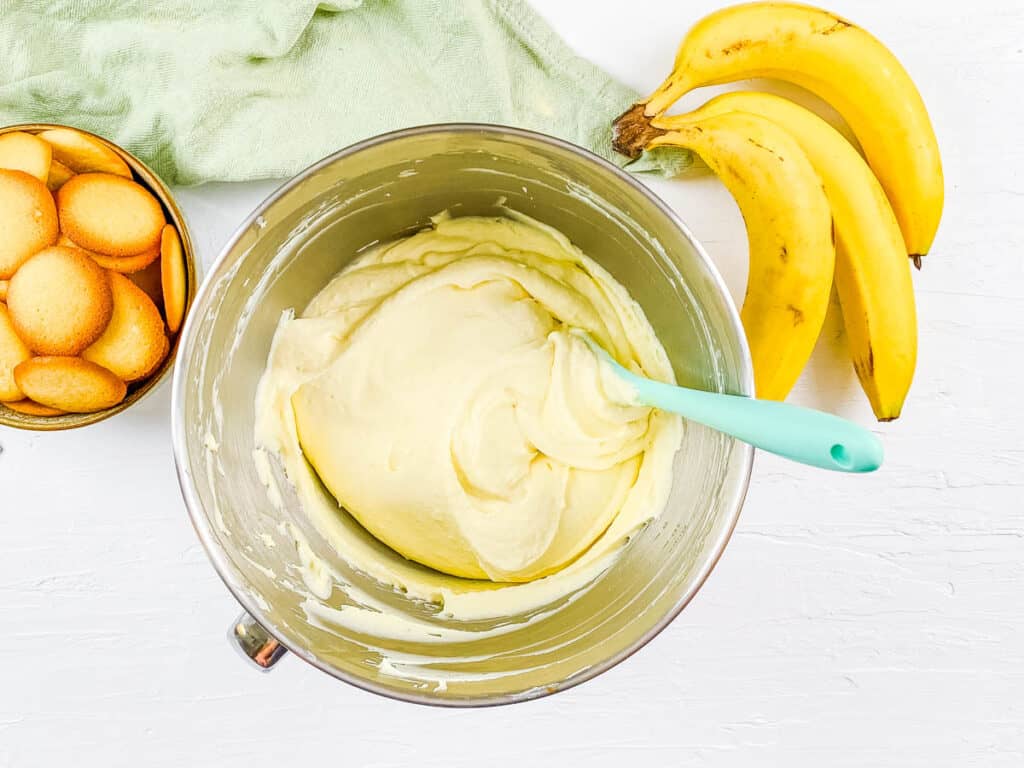 Cheesecake filling for banana pudding lasagna in a mixing bowl.