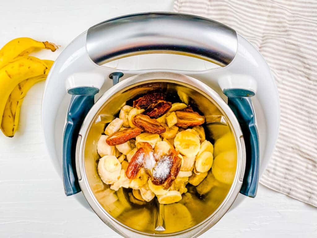 Bananas and dates being blended in a food processor.