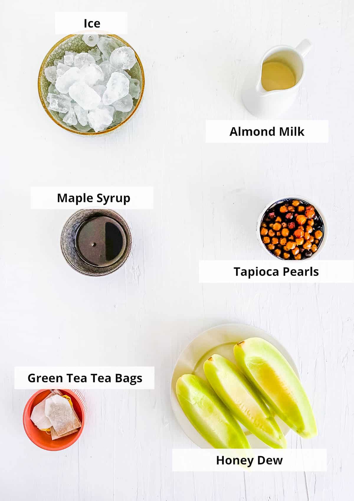 Ingredients for homemade honeydew milk tea recipe on a white background.